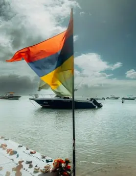 Mauritius national flag planted on a sandy tropical beach